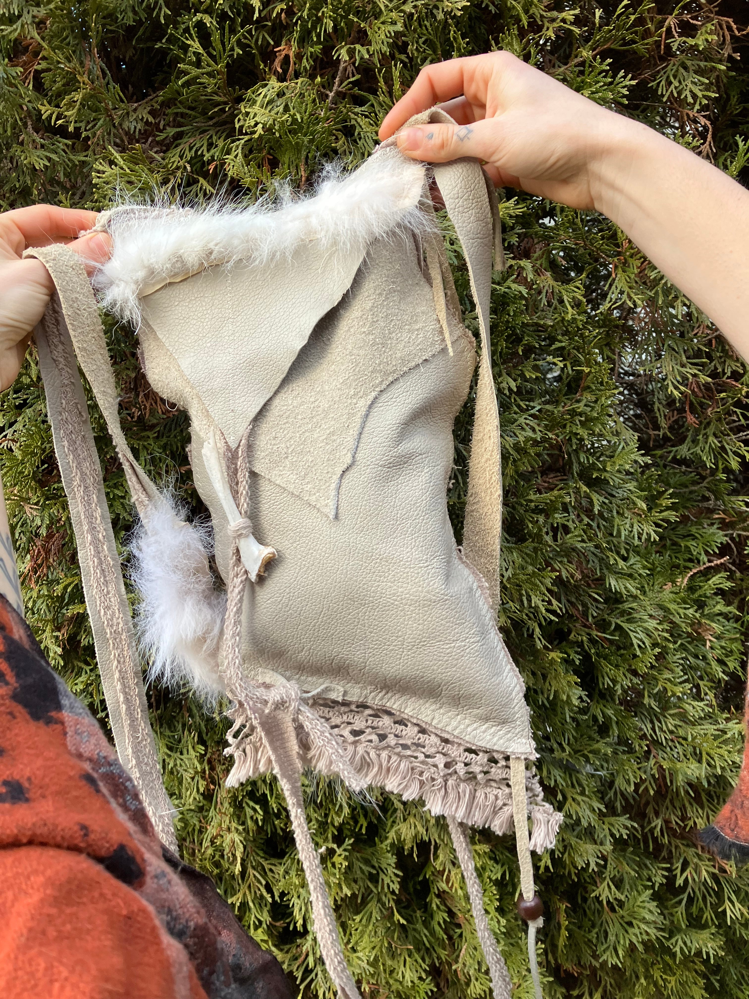 leather purse with cayote fur, feather, bone & cotton details