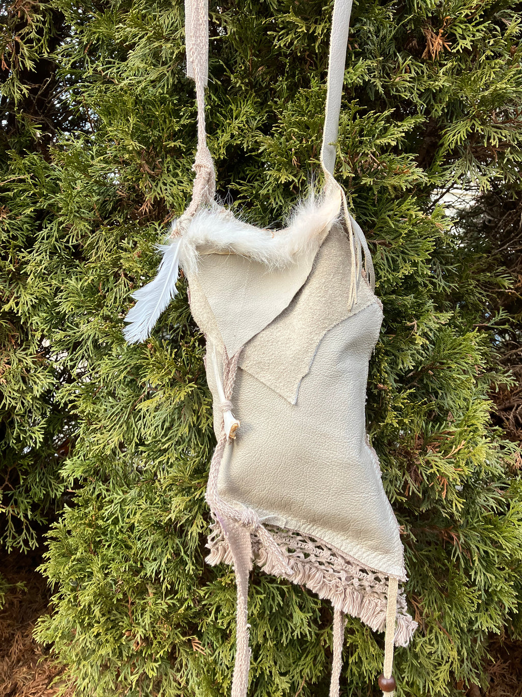 leather purse with cayote fur, feather, bone & cotton details