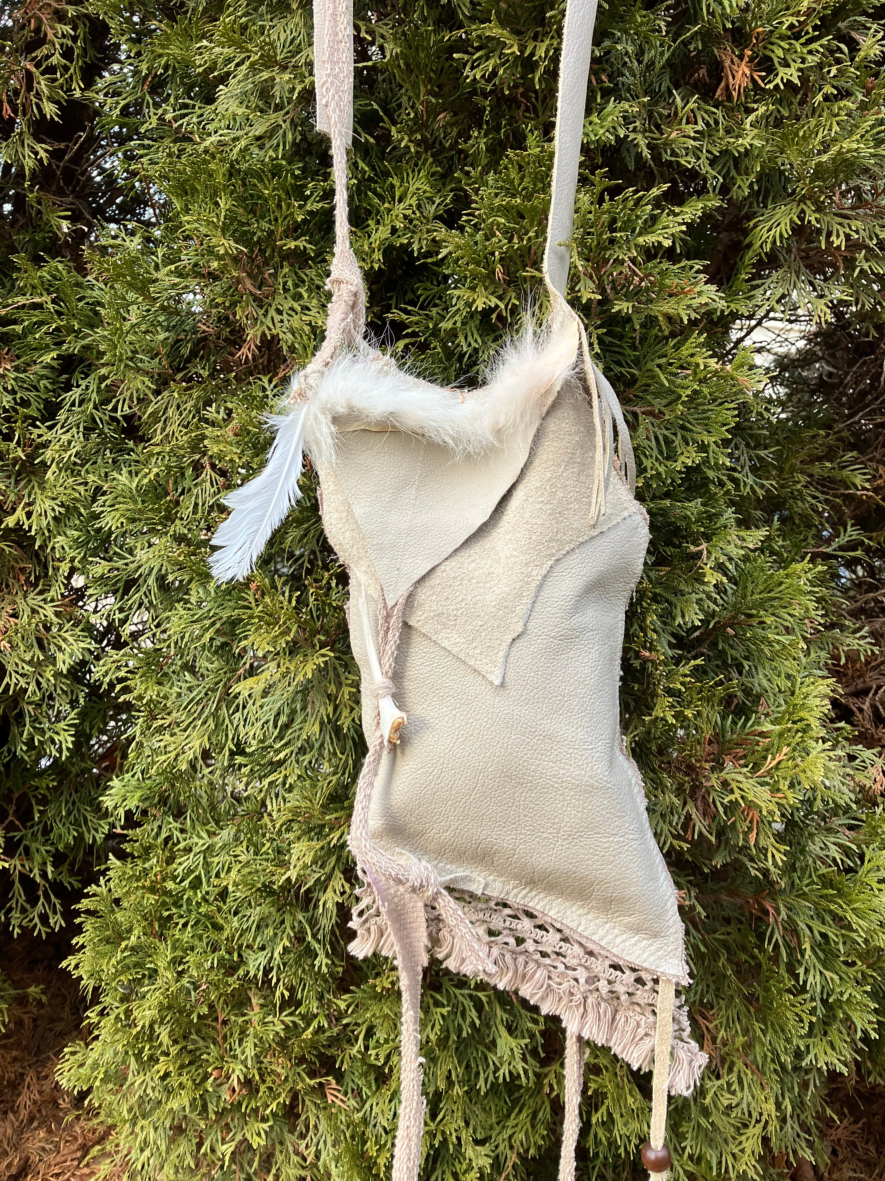 leather purse with cayote fur, feather, bone & cotton details