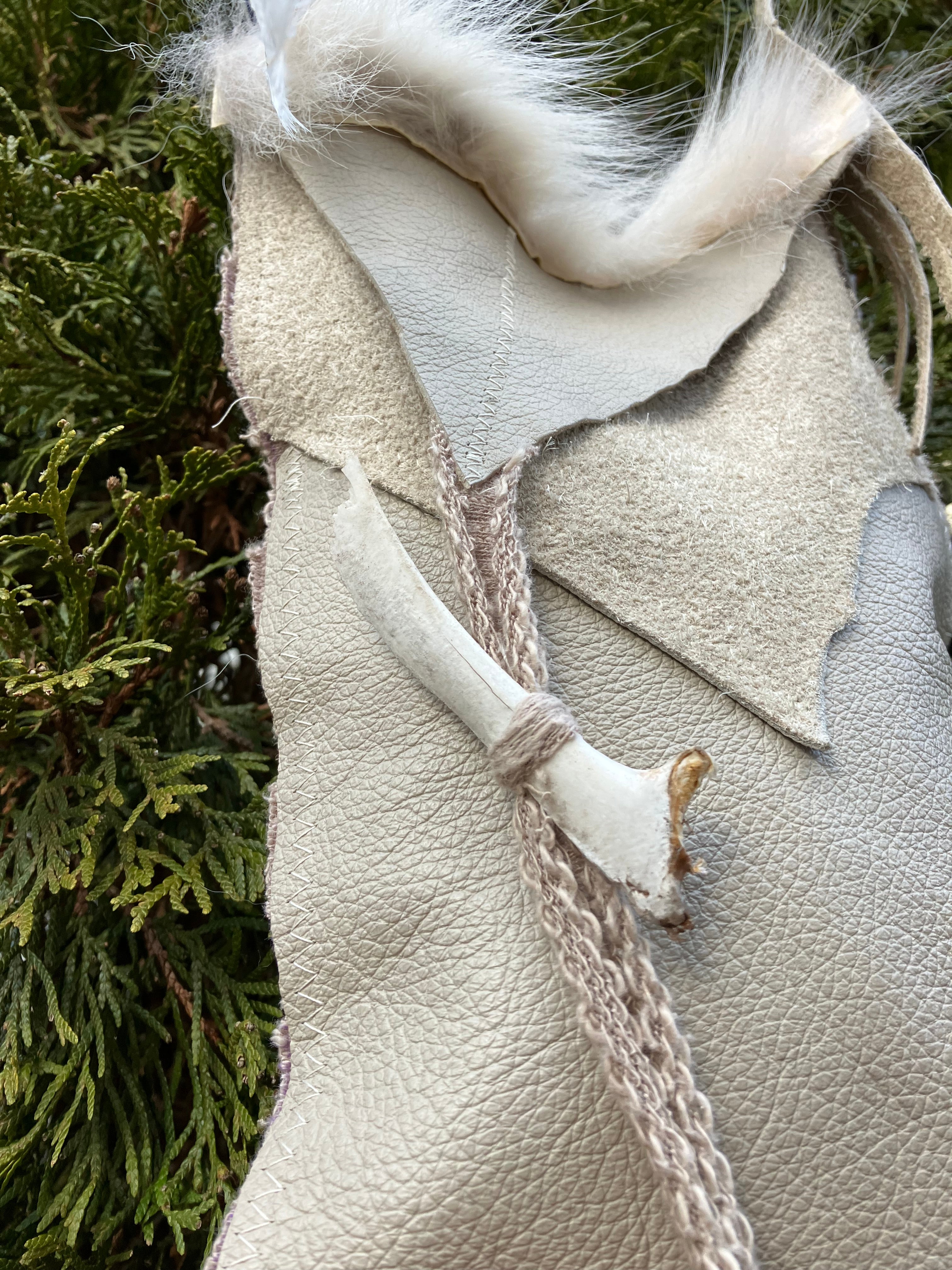 leather purse with cayote fur, feather, bone & cotton details